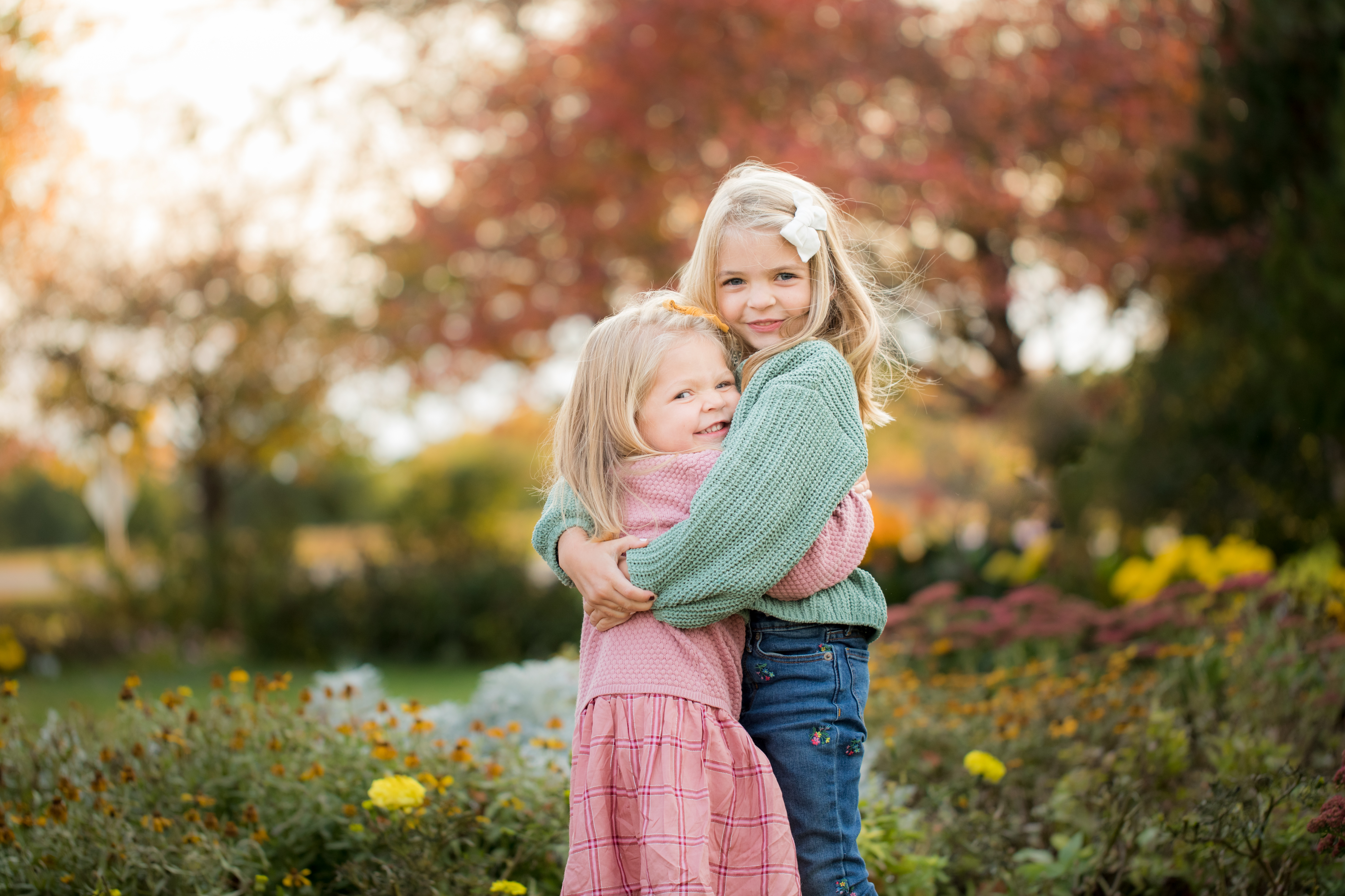 two sisters hugging in field photography