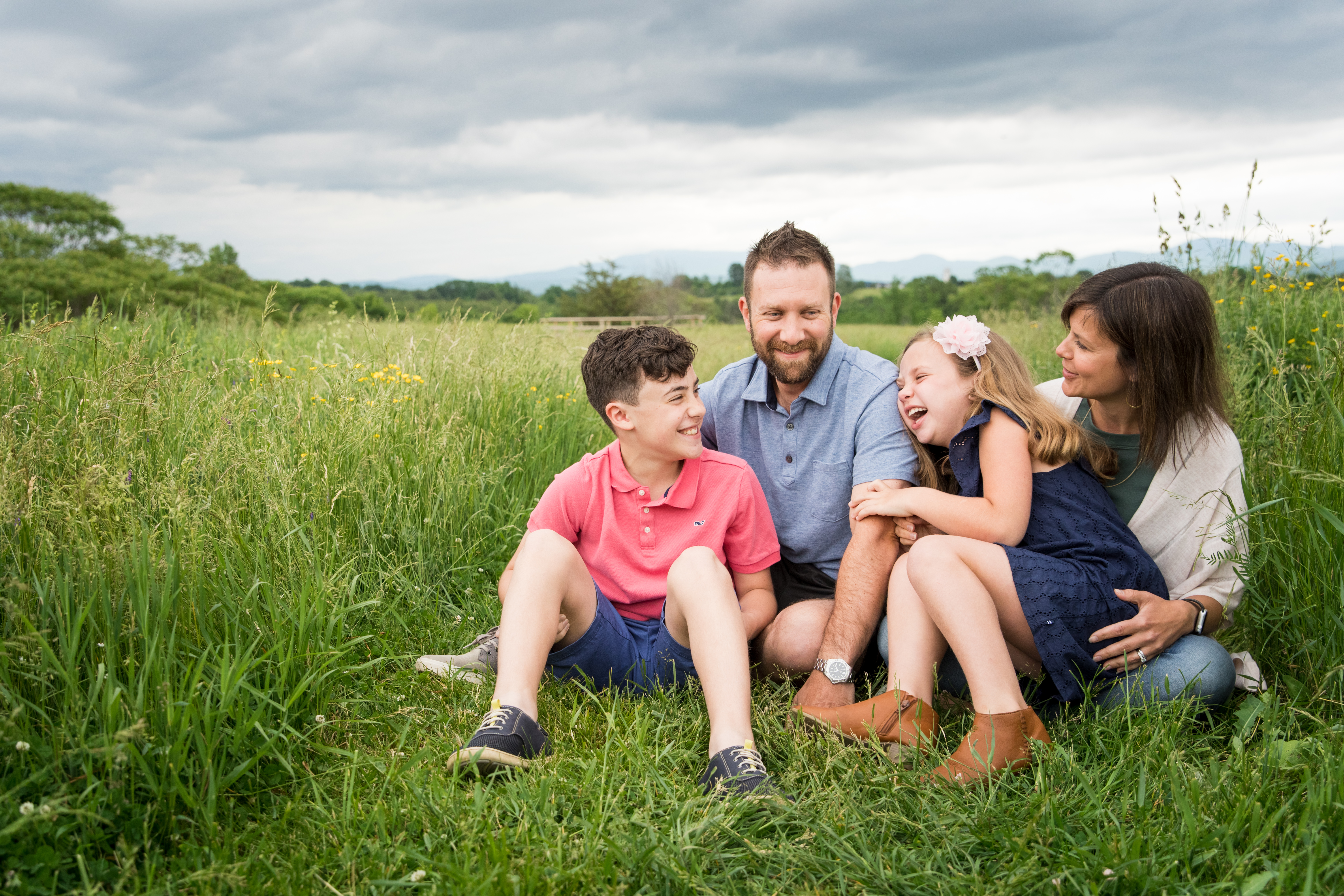 family of four sitting in field